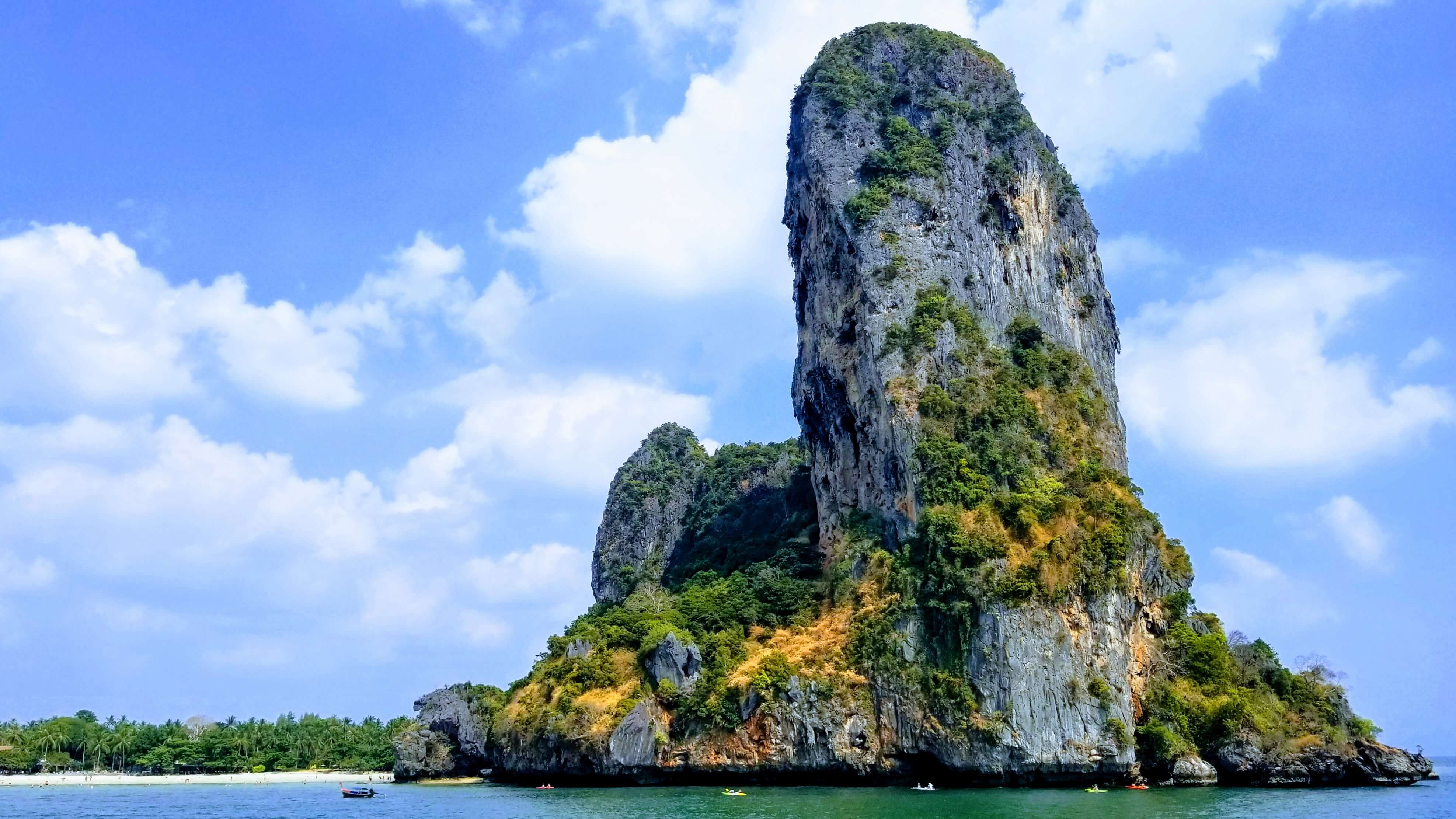 Large limestone rock formations jutting out of the Andaman Sea called karsts near Railay Beach.