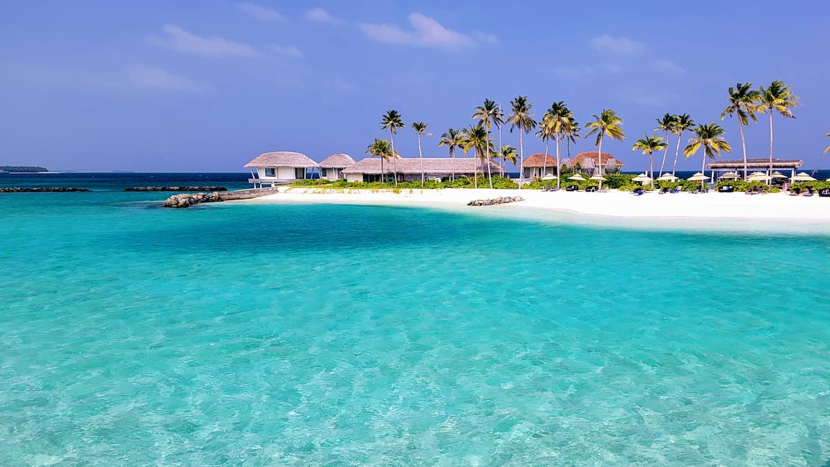 Clear blue water and white sand beach at the Radisson Blu Resort on Huruelhi Island Maldives on one of our winter vacation destinations